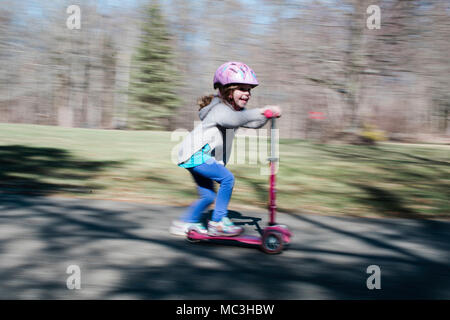 Schuß von kleinen Mädchen reiten ein scooter geschwenkt Stockfoto