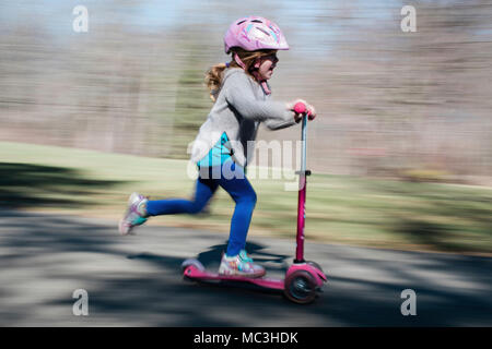 Schuß von kleinen Mädchen reiten ein scooter geschwenkt Stockfoto