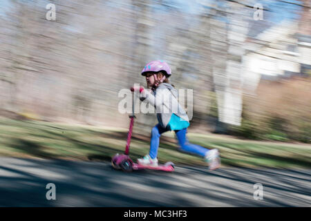 Schuß von kleinen Mädchen reiten ein scooter geschwenkt Stockfoto