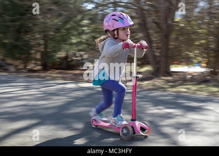 Schuß von kleinen Mädchen reiten ein scooter geschwenkt Stockfoto