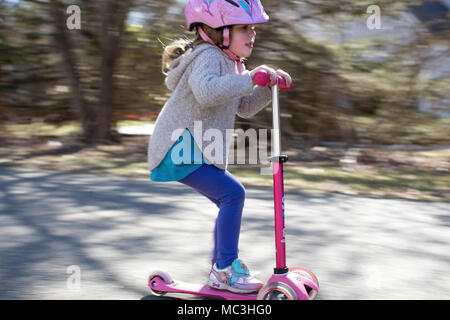 Schuß von kleinen Mädchen reiten ein scooter geschwenkt Stockfoto