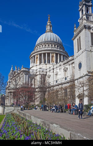 Stadt von London. Die Menschen genießen die Sonne im April die St Paul's Kathedrale Gärten. Der Turm von St. Augustine Watling Street befindet sich auf der rechten Seite Stockfoto