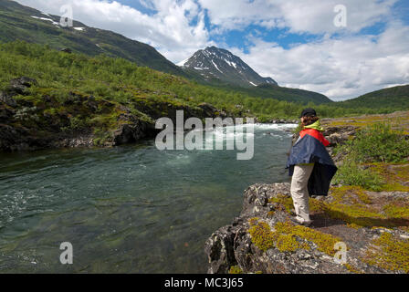 Trekker in der Nähe von einem Fluss in Stora Sjofallet Nationalpark, Norrbotten County, Schweden Stockfoto