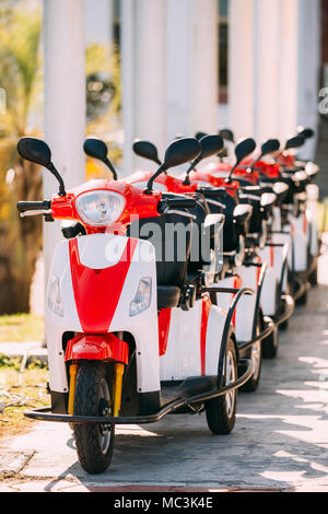 Viele Vermietung elektrische Motorräder, Motorräder Motorroller geparkt In der Zeile in der Straße der Stadt. Stockfoto