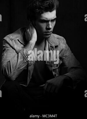 Denken schwere Depression charismatische Mann auf dunklen Schatten dramatisch hellen Hintergrund. Closeup Portrait. Art. Schwarz und Weiß Stockfoto