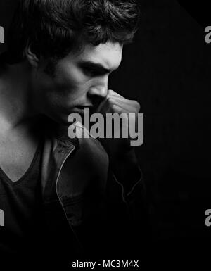 Denken schwere Depression charismatische Mann auf dunklen Schatten dramatisch hellen Hintergrund. Closeup Portrait. Schwarz und Weiß. Kunst Stockfoto