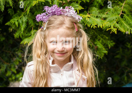 Adorable blonde Mädchen mit lila Blumen Kopfbügel Stockfoto