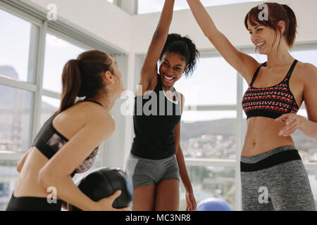 Gruppe von jungen sportlichen Mädchen im Fitness Studio genießen während Training Session. Multi-ethnischen Frauen zusammen trainieren und lächelnd in der Turnhalle. Stockfoto