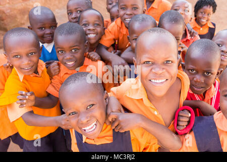 Uganda. 13. Juni 2017. Eine Gruppe von Happy Grundschulkinder lächeln, lachen und winken an einer Grundschule. Stockfoto