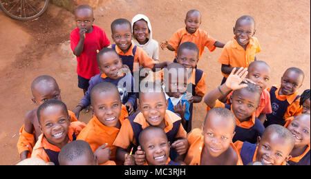 Uganda. 13. Juni 2017. Eine Gruppe von Happy Grundschulkinder lächeln, lachen und winken an einer Grundschule. Stockfoto