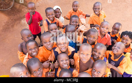 Uganda. 13. Juni 2017. Eine Gruppe von Happy Grundschulkinder lächeln, lachen und winken an einer Grundschule. Stockfoto