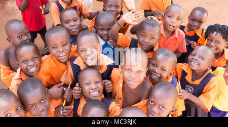 Uganda. 13. Juni 2017. Eine Gruppe von Happy Grundschulkinder lächeln, lachen und winken an einer Grundschule. Stockfoto