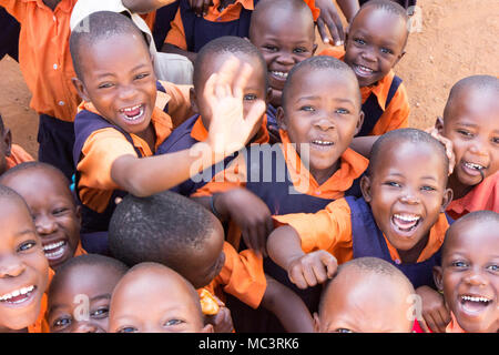 Uganda. 13. Juni 2017. Eine Gruppe von Happy Grundschulkinder lächeln, lachen und winken an einer Grundschule. Stockfoto