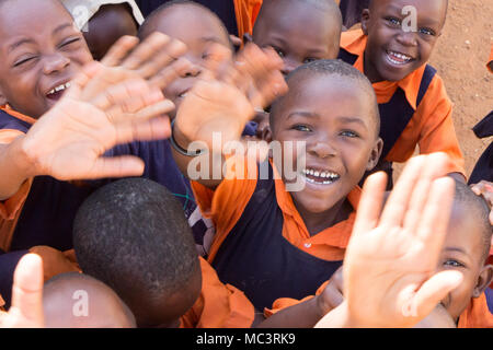 Uganda. 13. Juni 2017. Eine Gruppe von Happy Grundschulkinder lächeln, lachen und winken an einer Grundschule. Stockfoto