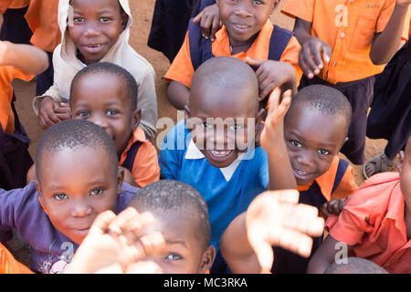 Uganda. 13. Juni 2017. Eine Gruppe von Happy Grundschulkinder lächeln, lachen und winken an einer Grundschule. Stockfoto