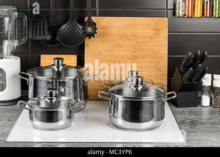 Edelstahl Töpfe in der Küche auf weißem Induktionsherd Essen kochen Hintergrund Stockfoto