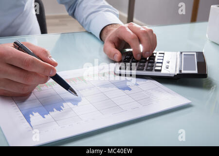 Foto der Unternehmer Hand Analyse Grafik mit Taschenrechner Stockfoto