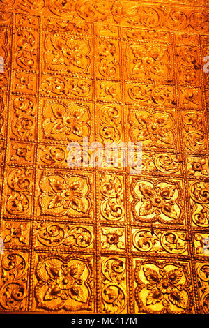 Nahaufnahme eines Golden Wall mit Blumen innerhalb der buddhistischen Botataung Pagode, Yangon, Myanmar. Stockfoto