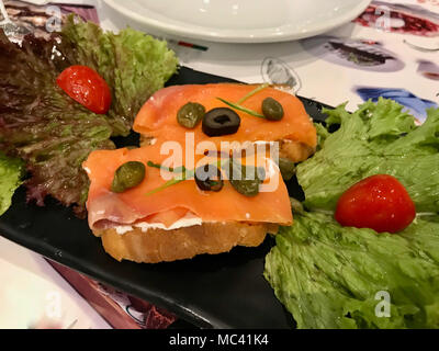 Geräucherter Lachs und Frischkäse auf knuspriges Brot als Vorspeise essen. Stockfoto