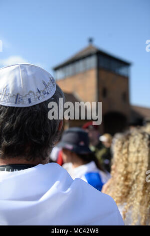 Teilnehmer am Haupttor des ehemaligen deutschen Konzentrationslager Auschwitz-Birkenau während der 'March der Lebenden" in Oswiecim gesehen. Die jährlichen März ehrt die Opfer des Holocaust im ehemaligen deutschen Vernichtungslager Auschwitz-Birkenau im südlichen Polen. Stockfoto