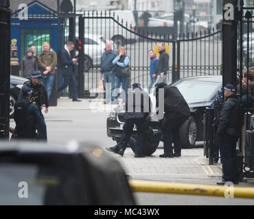 Downing Street, London, UK. 12. April 2018. Ein demonstrant vor einer Ministerkonferenz Auto an den Toren zur Downing Street anreisen, als Minister aus der Aussparung für einen besonderen Kabinettssitzung diskutieren Antwort auf chemischen Angriff in Syrien gezogen. Credit: Malcolm Park/Alamy Leben Nachrichten. Stockfoto