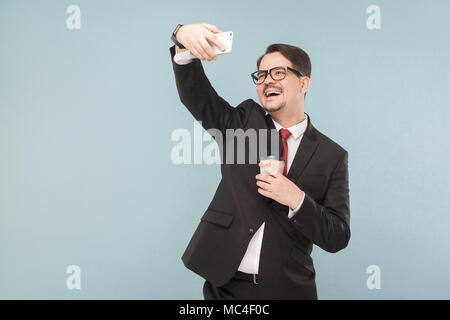 Business, Gadgets, Technologien. Business Mann toothy Lächeln, Foto. Innen-, Studio shot, von blauen oder grauen Hintergrund isoliert Stockfoto