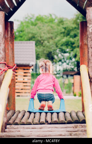 Wenig kleinkind Mädchen auf dem Spielplatz stehen auf Folie Stockfoto