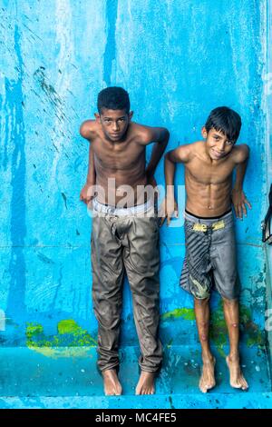 Zwei Kinder, die in Armut leben, erwarten Ihre Kleidung in einen Brunnen in einem Plaza in Caracas, Venezuela zu trocknen. Caracas, Dezember, 22, 2016 Stockfoto