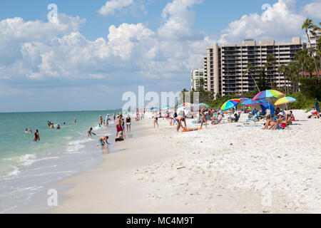 Urlauber in Naples, Florida genießen Aktivitäten am Strand. Sonnenbaden und Spaß am Strand. Stockfoto