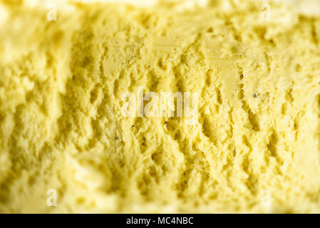 Schaufelte Vanilleeis Hintergrund. Sommer essen Konzept, Kopieren, Ansicht von oben. Süße Joghurt Dessert oder gelbe Eis Textur. Stockfoto