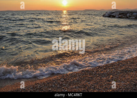 Kleine Wellen an der Küste während der Goldenen Stunde entlang der Küste kommen. Eine kühne und dramatische Szene von Blau, frisches Wasser. Horizontale, kopieren. Stockfoto