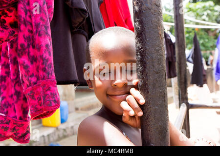 Lugazi, Uganda. 14. Mai 2017. Das Porträt einer wunderschönen ugandischen Mädchen unter Trocknen von Wäsche. Stockfoto