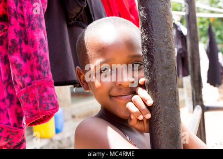 Lugazi, Uganda. 14. Mai 2017. Das Porträt einer wunderschönen ugandischen Mädchen unter Trocknen von Wäsche. Stockfoto