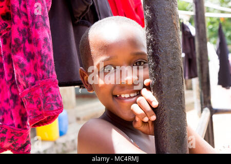 Lugazi, Uganda. 14. Mai 2017. Das Porträt einer wunderschönen ugandischen Mädchen unter Trocknen von Wäsche. Stockfoto