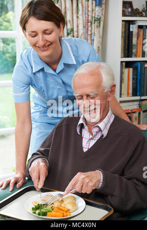 Pflegeperson das Mittagessen für den älteren Menschen Stockfoto