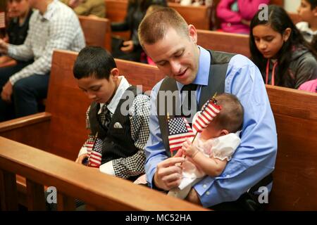 CAMP FOSTER, Okinawa, Japan - ein Vater sein Kind mit Komfort eine amerikanische Flagge vor einer Einbürgerung Zeremonie Jan. 31 an Bord Camp Foster, Okinawa, Japan. Familien und Freunde versammelten ihre Lieben in ihrer endgültigen Schritt auf dem Weg zur US-Bürger zu unterstützen. Elf Kandidaten aus sieben verschiedenen Ländern standen vor ihren Familien, hob ihre rechte Hand und wiederholte den Eid der Treue ihre Staatsbürgerschaft zu erhalten. (U.S. Marine Corps Foto von Pfc. Nicole Rogge) Stockfoto