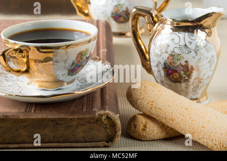 Morgens Kaffee und Cookies Savoiardi auf dem Tisch mit einem Vintage Geschirrset aus der Deutschen Porzellan des 19. Jahrhunderts Stockfoto