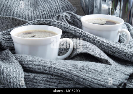 2 weiße Tassen Kaffee in Hautfalten grauer Wolle Schal enger gewickelt - oben Stockfoto