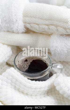 Transparentes Glas Becher mit heißem Kaffee verpackt in einer weißen Schal mit geringer Tiefe des Fokus. Stockfoto