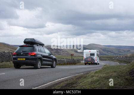 Schwarzes Auto und Camper unterwegs auf der Landstraße in der Nähe von Winnats Pass im Peak District, Derbyshire, UK an bewölkten Frühling. Stockfoto