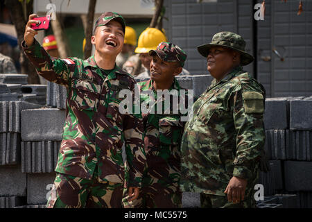 Indonesische Armee Soldaten nehmen ein selfie mit einer Royal Thai Army Soldat vor einer Säule Anhebung Zeremonie für ein Schulgebäude für die Unterstützung der Übung Cobra Gold 2018 Banthungsohongsa Schule in Chachoengsao, Königreich Thailand, 31.01.2018. Humanitäre civic Hilfe Projekte während der Übung die Unterstützung und humanitären Interessen des thailändischen Volkes durchgeführt. Cobra Gold 18 ist eine jährliche Übung im Königreich Thailand durchgeführt und läuft vom 13-23 Februar mit sieben voll teilnehmenden Nationen. (U.S. Marine Corps Foto von Sgt. Matthew J. Bragg) Stockfoto