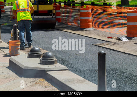 Arbeitnehmer, die Asphalt fertiger während Straßenbauarbeiten Instandsetzung Stockfoto