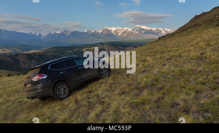 Crossover Nissan X-Trail auf einem Hang in Kurai Steppe vor dem Hintergrund des Nordens Chuy ridge in der Morgendämmerung. Stockfoto