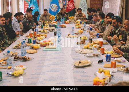 Top Berater von Task Force (Südwest) (TFSW) und der afghanischen nationalen Verteidigungs- und Sicherheitskräfte (ANDSF) teilen sich eine Mahlzeit zusammen nach einer Sicherheit Shura bei Bost Flugplatz, Afghanistan, Jan. 25, 2018. Top Berater aus TFSW und führenden Persönlichkeiten aus dem ANDSF kamen zusammen, um zu diskutieren, zu Aktionen für den Betrieb Maiwand 11. Sie erörterten ferner die vorläufigen Sicherheitslösungen weitere Stärkung der Helmand Sicherheit und Stabilität in der Region. (U.S. Marine Corps Foto von Sgt. Conner Robbins) Stockfoto