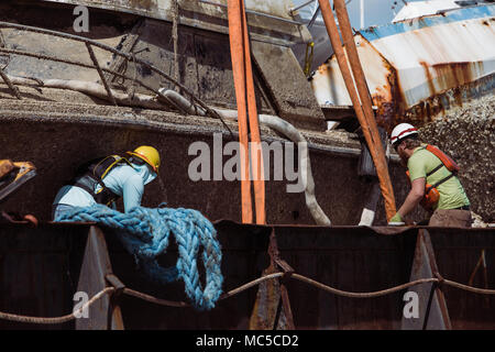 FAJARDO, Puerto Rico, Jan. 30, 2018 - Arbeitnehmer einstellen, Träger eines Schiffes zu heben und aus dem Schiff zu entfernen. Der Umweltschutz Agency (EPA), das in Zusammenarbeit mit dem U.S. Coast Guard (USCG) und FEMA, hat die Mission, die die Identifizierung und die ordnungsgemäße Entsorgung der Schiffe und ihrer gefährlichen Abfällen und Elektronik. Bisher haben 377 Schiffe wurden identifiziert, und 242 Schiffe und ihre Abfälle ordnungsgemäß entfernt worden. Die FEMA/Eduardo Martinez Stockfoto