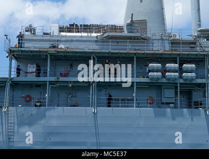 SANTA Rita, Guam (April 04, 2018) Matrosen an Bord der U-Boot Tender USS Emory S. Land (39), Wave goodbye, wie das Schiff Transite Apra Harbor, als sie unterwegs für eine Bereitstellung erhält, April 4. Emory S Land, nach Guam, Reparaturen, rearm bereitgestellt und reprovisions eingesetzten US-Seestreitkräfte im Indo-pazifischen Region. (U.S. Marine Foto von Mass Communication Specialist 3. Klasse Josh Coté/Freigegeben) Stockfoto