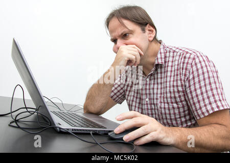Der verwirrte unglücklich Benutzer ist auf der Suche auf den Bildschirm. Überrascht betonte Mann am Laptop. System Fehler auf dem Computer. Stockfoto