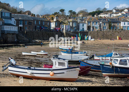 Kleine Fischerboote hoch und trocken auf dem Strand im Hafen im malerischen Dorf Mousehole in der Nähe von Penzance an der Küste von Cornwall. Stockfoto