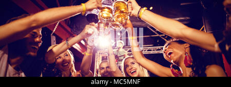 Freunde toasten Biergläser am Tisch in der Verein Stockfoto