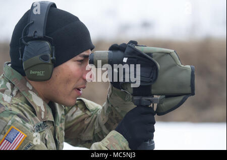 Armee SPC. Arturo Dominguez, ein Eingeborener von Okeechobee, Fla., Charlie Truppe, 1st Squadron, 40th Cavalry Regiment (Airborne), 4 Infantry Brigade Combat Team (Airborne), 25 Infanterie Division, U.S. Army Alaska zugewiesen sind, verwendet ein Spektiv Genauigkeit ihn ein Soldat mit einem M2010 Enhanced Scharfschützengewehr auf Statler Strecke am Joint Base Elmendorf-Richardson, Alaska, 6. April 2018, während der Treffsicherheit Training zu beobachten. Hauptaufgabe ist ein Sniper ist diskriminierend, hoch präzise Gewehr Feuer gegen feindliche Ziele, die nicht erfolgreich engagiert durch die regelmäßige rifleman Aufgrund liefern Stockfoto